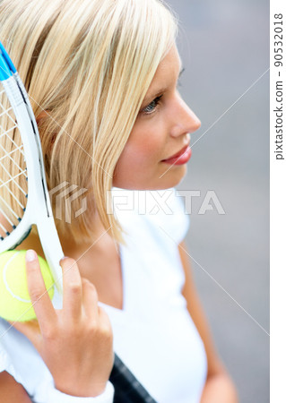 Feeling fully focused on winning. A young female tennis player with her racquet and ball in her hand. Feeling fully focused on winning. A young female tennis player with her racquet and ball in her hand. 90532018