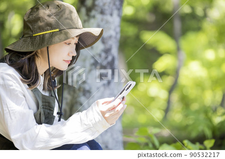 Outdoor girls looking at smartphones while chairing 90532217