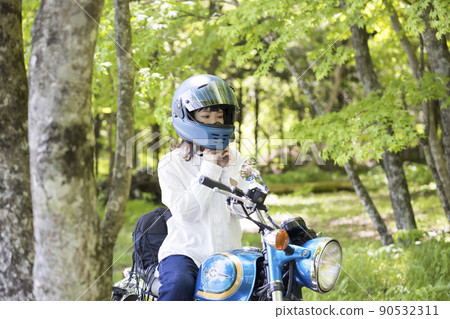 Bike girls wearing (taking off) helmets in the forest Bike girls wearing (taking off) helmets in the forest 90532311