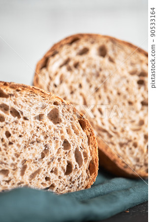 The process of making wheat bread at home. A slice of homemade sourdough bread. The concept of healthy homemade food. Front view. The process of making wheat bread at home. A slice of homemade sourdough bread. The concept of healthy homemade food. Front view. 90533164