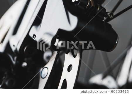 Shiny bicycle brake rotor close-up in macro with selective focus 90533415