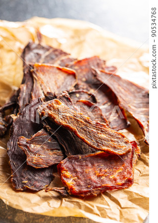 Beef jerky meat. Dried sliced meat on paper. 90534768