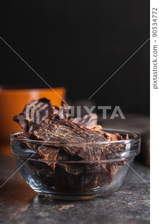 Beef jerky meat. Dried sliced meat in bowl. 90534772