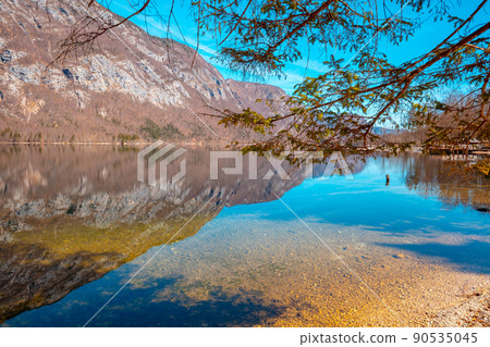 Rocky shore of the mountain lake. Beautiful nature. Reflection on the lake Rocky shore of the mountain lake. Beautiful nature. Reflection on the lake 90535045