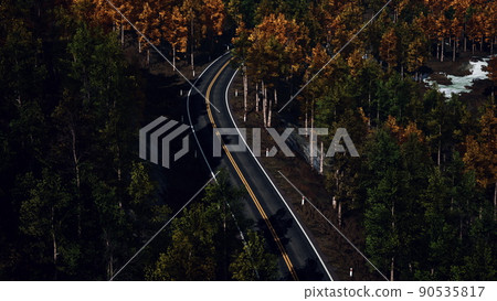 Aerial over a winding forest road in Finland during sunset 90535817