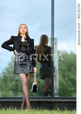 Gorgeous young woman in black leather skirt and wool jacket Gorgeous young woman in black leather skirt and wool jacket 90536108