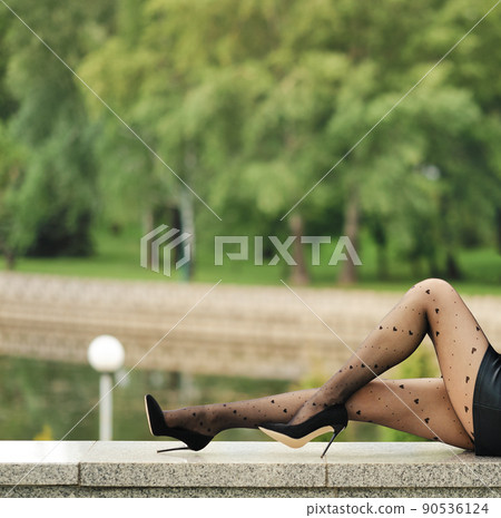 Slim female legs in tights with heart pattern outdoors 90536124
