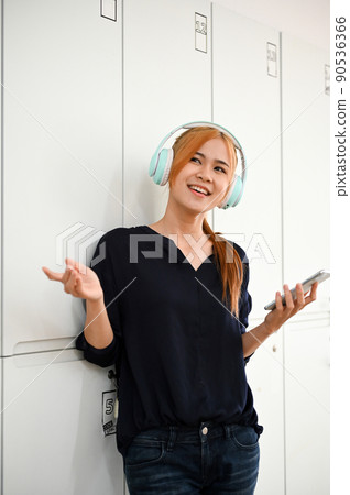 Carefree and joyful asian millennial woman listening to the music the headphones. Carefree and joyful asian millennial woman listening to the music the headphones. 90536366