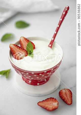 fresh homemade greek yogurt with strawberries in a red bowl fresh homemade greek yogurt with strawberries in a red bowl 90536862