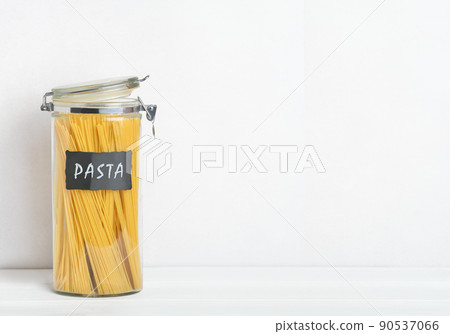 Organization of storage in the kitchen. Pasta in glass container on a kitchen table. Zero waste storage.  90537066