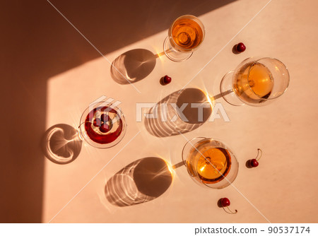 Summer cocktails with fruit in the sunlight. Fresh juicy beverages in glasses with shadows making trendy pattern on beige background. Delicious lemonade, cold tea, soda and water Summer cocktails with fruit in the sunlight. Fresh juicy beverages in glasses with shadows making trendy pattern on beige background. Delicious lemonade, cold tea, soda and water 90537174