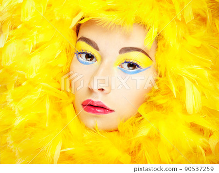Portrait of beautiful girl in yellow feathers. Perfect makeup Portrait of beautiful girl in yellow feathers. Perfect makeup 90537259