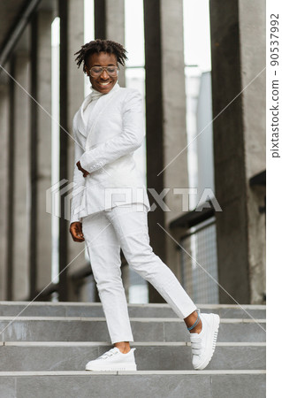 Portrait of a smiling african woman in glasses, walking in the modern city, smiling to camera. Portrait of a smiling african woman in glasses, walking in the modern city, smiling to camera. 90537992