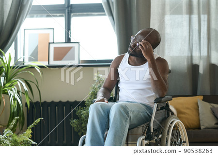 African American man sitting in wheelchair alone in the room and thinking about something African American man sitting in wheelchair alone in the room and thinking about something 90538263