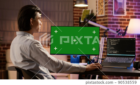 Male entrepreneur using computer display with greenscreen to work on business. Looking at isolated chroma key template with blank copyspace and mockup background on pc, digital software. Male entrepreneur using computer display with greenscreen to work on business. Looking at isolated chroma key template with blank copyspace and mockup background on pc, digital software. 90538559