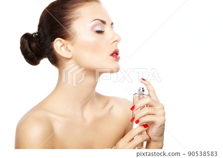 Young woman applying perfume on herself isolated on white background Young woman applying perfume on herself isolated on white background 90538583