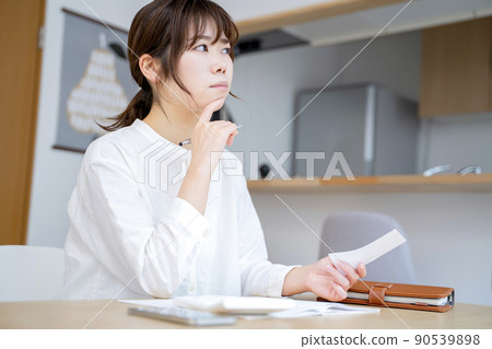 A woman holding a household account book 90539898