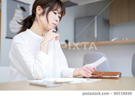 A woman holding a household account book 90539899