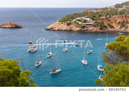 Port Brut at Cala d'Hort with a few white sailing yachts. 90540742