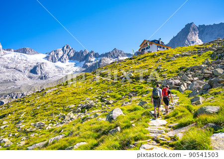 Two hikers ascending mountain hut 90541503