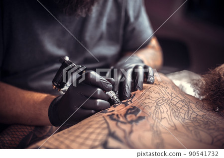 Master during a tattoo artist session the salon Master during a tattoo artist session the salon 90541732