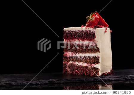 Piece of strawberry cake on a black background. 90541990