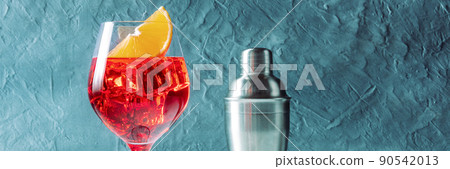 Aperol cocktail with an orange panorama, a side view with a shaker Aperol cocktail with an orange panorama, a side view with a shaker 90542013