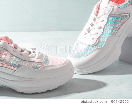 White pastel sneakers with sequins on geometric podiums on turquoise 90542962
