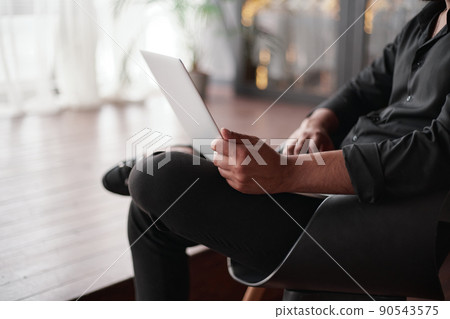 image of a business owner using a laptop in his store. image of a business owner using a laptop in his store. 90543575
