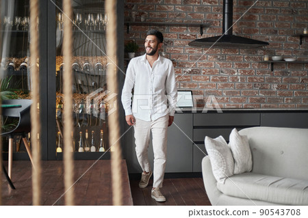 young man walking through the hall of a liquor store . 90543708