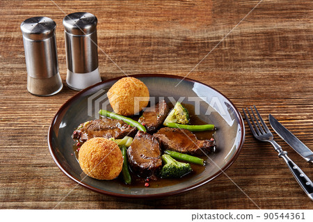 Stewed beef with vegetables on wooden background close up. Hot Meat Dishes. Top view 90544361