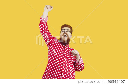 Funny happy crazy fat man standing on yellow background, raising his fist up and shouting YES Funny happy crazy fat man standing on yellow background, raising his fist up and shouting YES 90544407