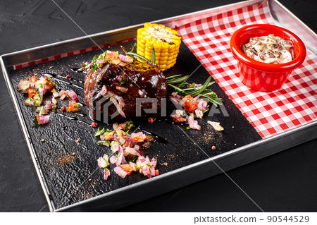 A piece of steak with salad, corn, mushrooms sauce on a blackboard A piece of steak with salad, corn, mushrooms sauce on a blackboard 90544529