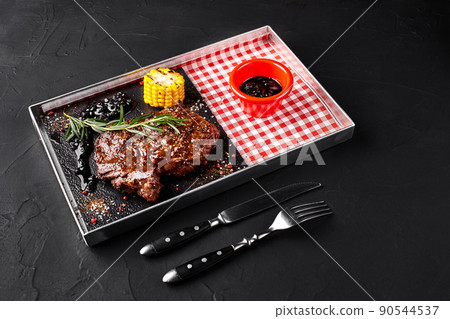 Roasted beef tenderloin with herbs, baked corn and rosemary-currant sauce. Top view 90544537