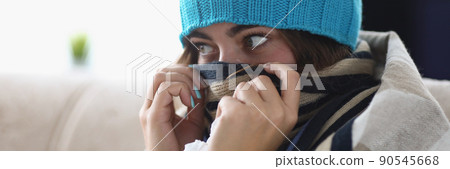Young woman hide nose in scarf feeling cold because of high temperature Young woman hide nose in scarf feeling cold because of high temperature 90545668