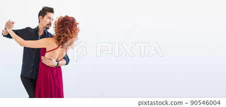 Banner social dance, bachata, kizomba, salsa, tango concept - Woman dressed in red dress and man in a black costume over white background with copy space Banner social dance, bachata, kizomba, salsa, tango concept - Woman dressed in red dress and man in a black costume over white background with copy space 90546004