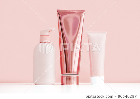 Mock up pink cosmetic bottle and tubes. Minimal monochrome composition of skin care products. 90546287