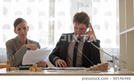 Businesspartners working together at their office desk Businesspartners working together at their office desk 90546466