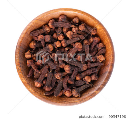 Dry cloves in wooden bowl, isolated on white background. Cloves spice. Spices and herbs. Top view. 90547198