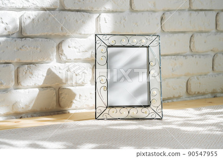 Photo frames on floor over white brick wall Photo frames on floor over white brick wall 90547955