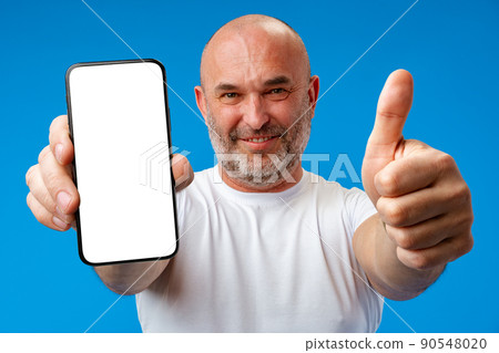 Middle-aged man showing blank smartphone screen with copy space against blue background 90548020