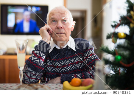 Lonely elderly man drinking alcohol at christmas table 90548381