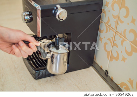 Handsome man using coffee machine in kitchen 90549262