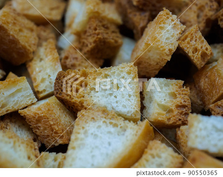 Selective focus on slices of fried white bread close-up. Tasty rosy croutons.  90550365
