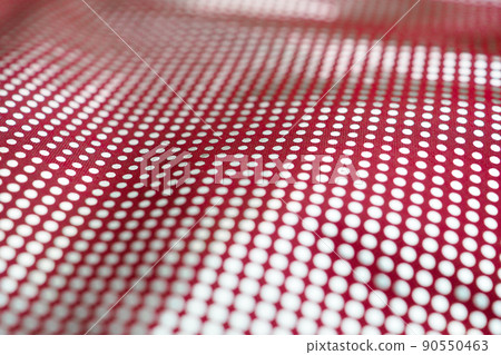 Selective focus on the surface of a red textile fabric with a pattern of silvery dots. Selective focus on the surface of a red textile fabric with a pattern of silvery dots. 90550463