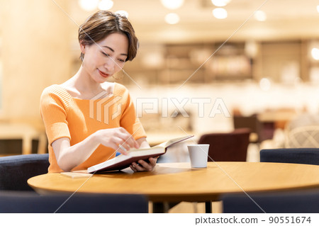 在咖啡館讀書的中年婦女 90551674