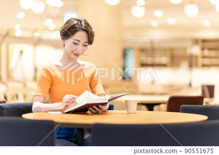在咖啡館讀書的中年婦女 90551675