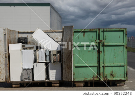 Electronic waste for recycling. Discarded household appliances in the garbage container Electronic waste for recycling. Discarded household appliances in the garbage container 90552248