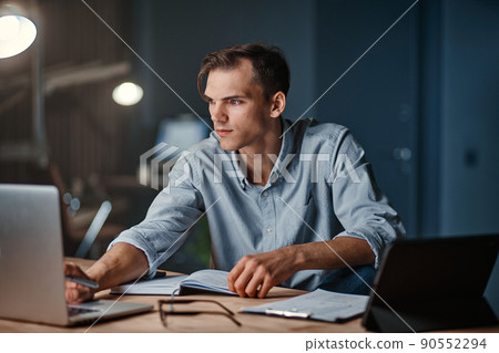 smiling businessman working on a new project at night . smiling businessman working on a new project at night . 90552294