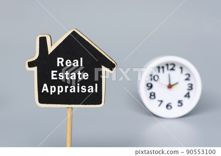 Real Estate Appraisal text on wooden house with blurred alarm clock background. Real Estate Appraisal text on wooden house with blurred alarm clock background. 90553100